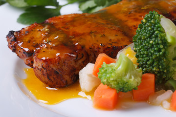 grilled meat with orange sauce and vegetables