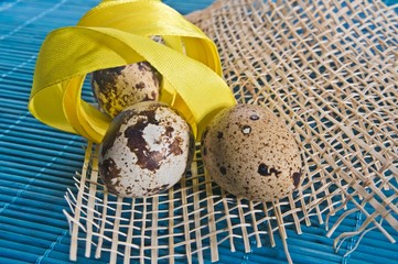 Easter background with quail eggs and ribbons