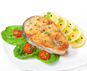 Fish dish- fried fish fillet with vegetables on white background