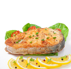 Fish dish- fried fish fillet with vegetables on white background