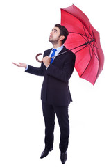 Handsome businessman with opened umbrella checking if its rainin