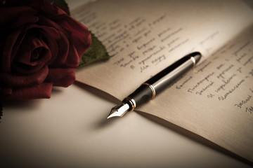 fountain pen on text sheet paper with rose
