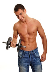 Young athletic man holds dumbbell and exercises biceps muscle.