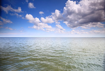 Cloudy blue sky above a surface of the sea