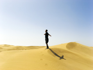 Fototapeta na wymiar man stretching in the dunes of Gran Canaria