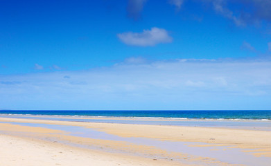 Fototapeta na wymiar Beautiful wide open beach with blue skies in Summer.