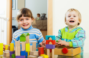  happy children playing with blocks  in home