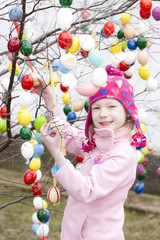 Fototapeta na wymiar little girl standing by Easter tree