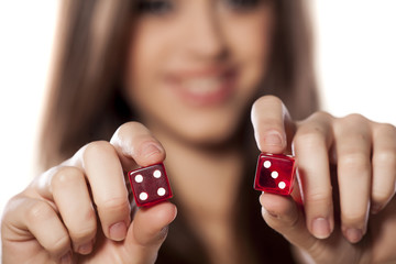 smiling girl holding a pair of dice for gambling