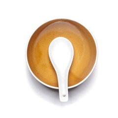 Orange plate and china spoon on white background