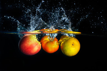 apples falling and splashing into clear water