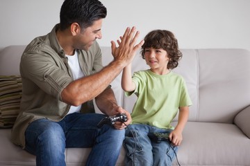 Father and son playing video games in living room