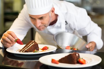 Fototapeta na wymiar Concentrated male pastry chef decorating dessert