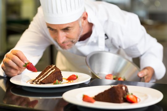 Concentrated male pastry chef decorating dessert