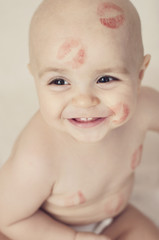 Happy child with red kisses on the skin