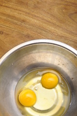 Two egg yolk in metallic bowl