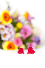 Hintergrund mit Blumenstrauß und zwei kleinen Herzen