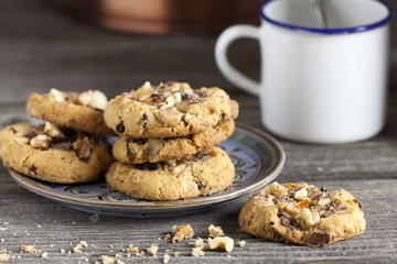 Kekse auf einem Teller und ein Kaffeebecher im Hintergrund