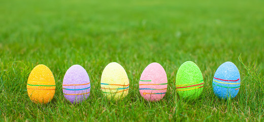 Multi-colored Easter eggs on green grass