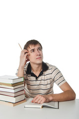 Male student at the table with pile of books