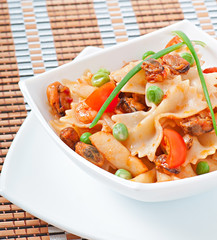 Farfalle pasta with seafood, cherry tomatoes and green peas