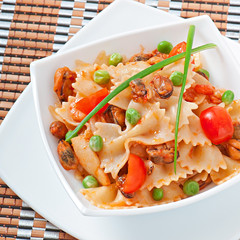 Farfalle pasta with seafood, cherry tomatoes and green peas
