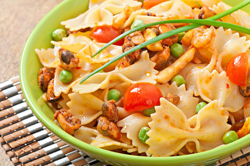 Farfalle pasta with seafood, cherry tomatoes and green peas