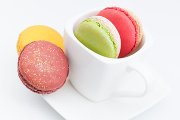 colorful macaroon in a cup on white background