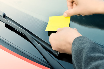 Yellow sticky note on a windshield