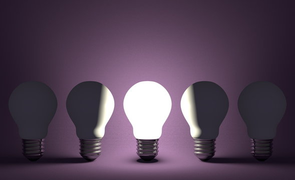 Glowing light bulb in row of switched off ones on violet