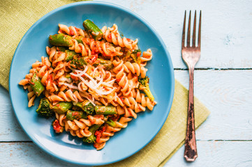 Pasta with vegetables and cheese on wooden background