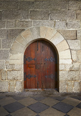 Fototapeta na wymiar Ancient wooden door in old stone castle in Guimaraes, Portugal