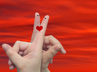 Fingers in love over sky