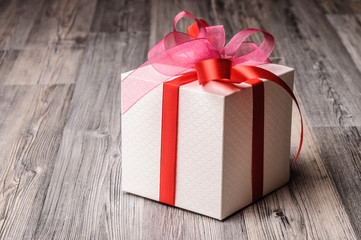 A festive gift box with pink and red ribbons