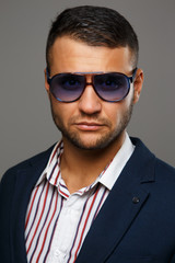 Fierce successful man in violet sunglasses