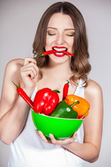 portrait of an attractive young woman holding up peppers
