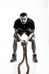 Fototapeta na wymiar man doing rope training isolated on white - boot camp
