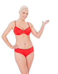 Obraz premium Attractive woman in bikini points to the side