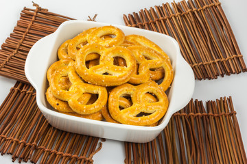 salted pretzels in a bowl on wooden table cloths