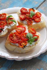 sandwiches with cheese and baked tomato on a white plate