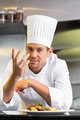 Smiling male chef with cooked food in kitchen