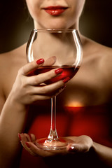 woman in red holding wine glass and smiles