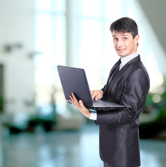 Portrait of businessman in front of laptop computer