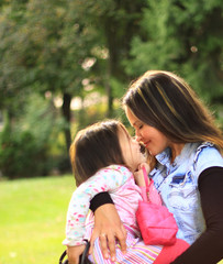 Smiling mother and little daughter on nature.