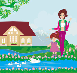 mother and daughter feed the swans