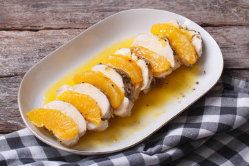Meat with slices of orange and yellow sauce