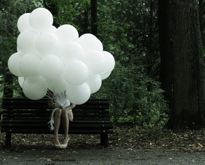 Sentimentality. Woman with Balloons in the Park on Bench