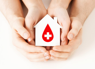 hands holding house with donor sign