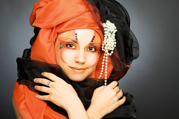 Young woman in black and orange turban
