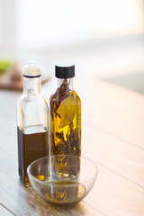 close up of two olive oil bottles and bowl of oil